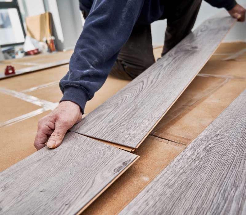 male worker installing laminate floor in apartment. male worker installing laminate floor in apartment.